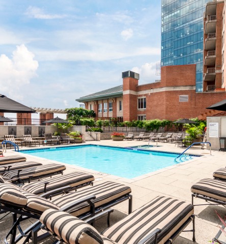 Pool deck with striped lounge chairs and city views at the Spinnaker apartment building in Harbor East