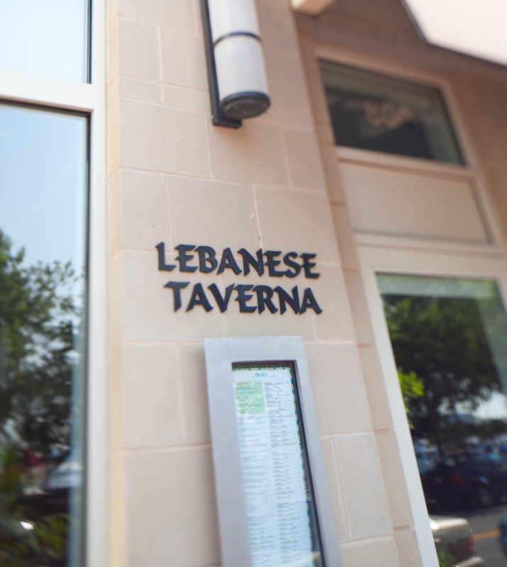 Cinderblock exterior storefront of Lebanese Taverna restaurant with black text sign
