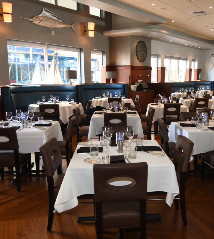 Fine dining interior of The Oceanaire Seafood Room featuring white table cloths and nautical decor