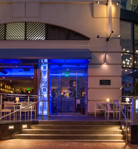 Nighttime exterior of Ouzo Bay restaurant-front, with inviting blue lighting