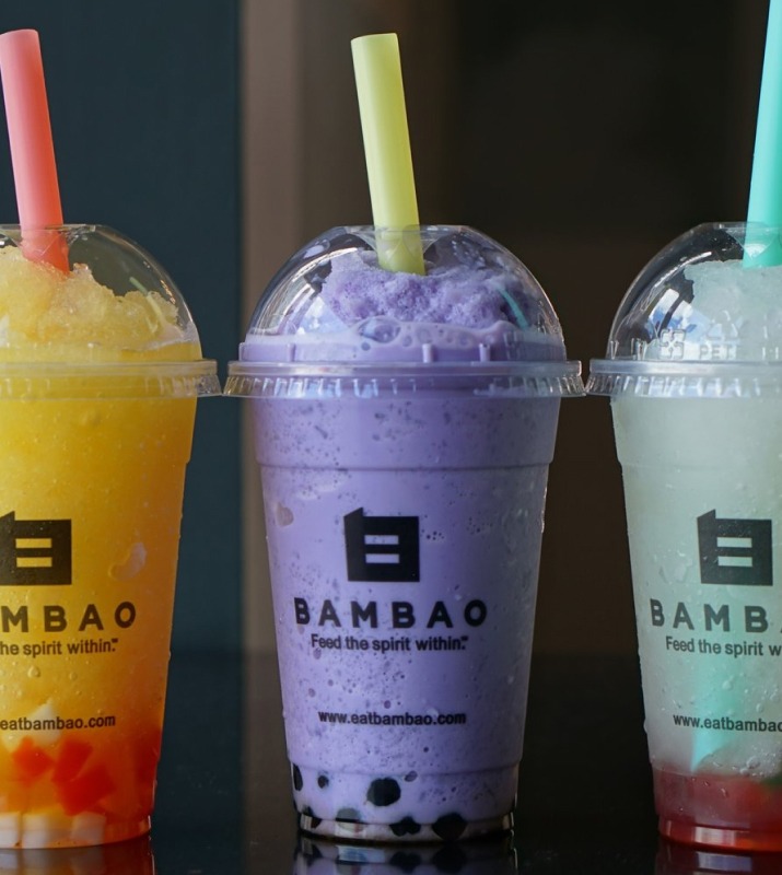 Closeup of three colorful Bambao bubble tea blended drinks in plastic labeled cups with lids