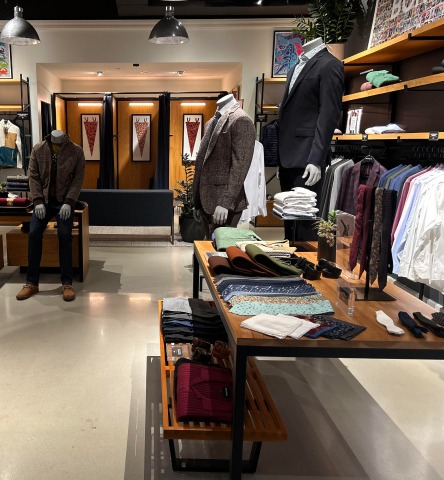 Interior of Bonobos retail store with mannequins outfitted in suits and displays with various ties and suit accessories