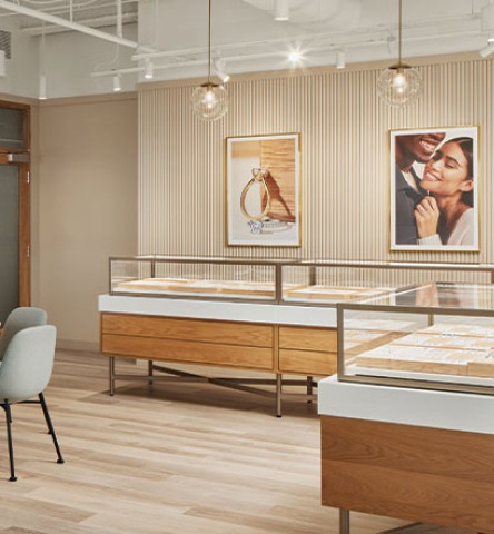 Interior of Brilliant Earth jewelers featuring large wooden and white jewelry cases, soft lighting, and neutral wooden floors