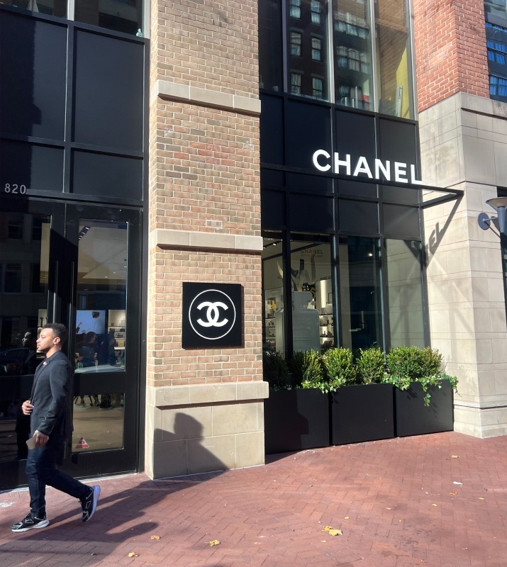 Man walking by the Chanel storefront in Harbor East