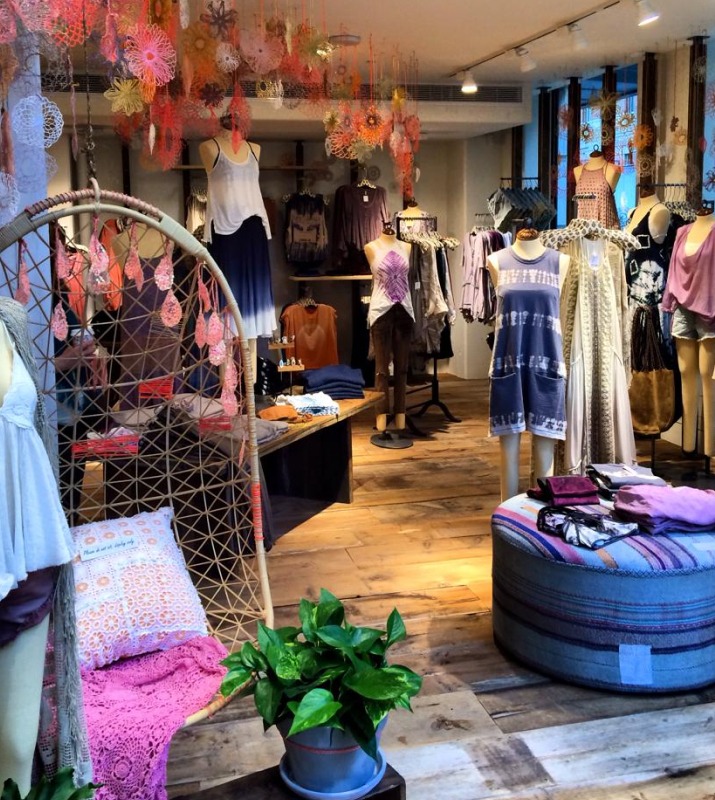Interior store display of Free People clothing boutique featuring textured chairs, and various women's boho clothing
