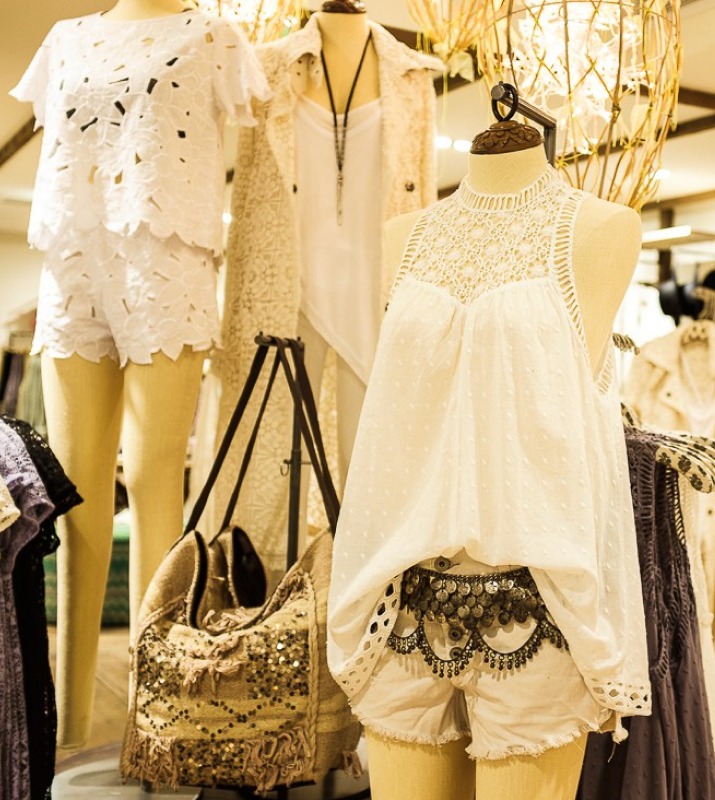 Closeup of mannequins wearing white summery boho clothing inside Free People