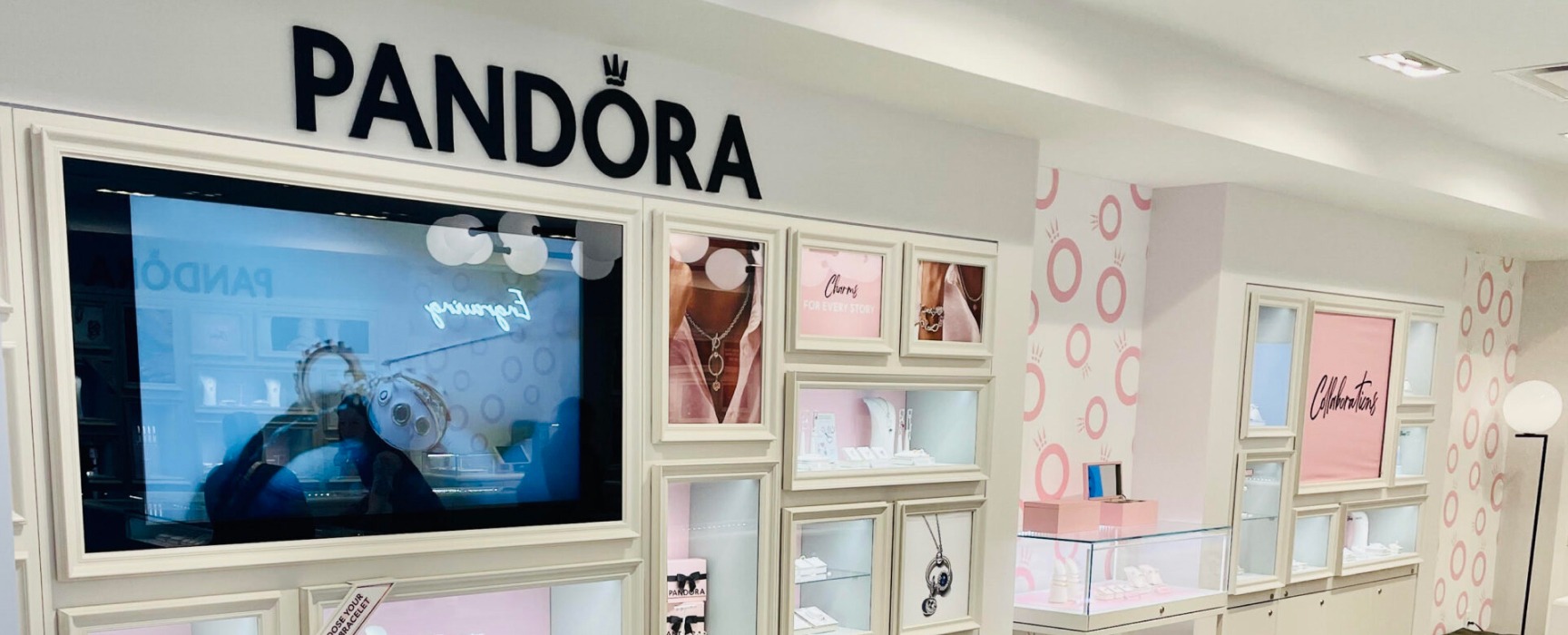 A screen shows off jewelry in the bright, clean showroom of Pandora in Harbor East