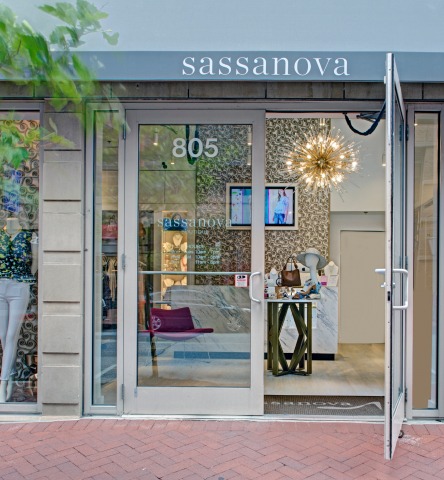 Glass entryway with an open door into clothing boutique Sassanova