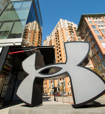 Large statue of the Under Armour logo in front of their retail store on the promenade in Harbor East