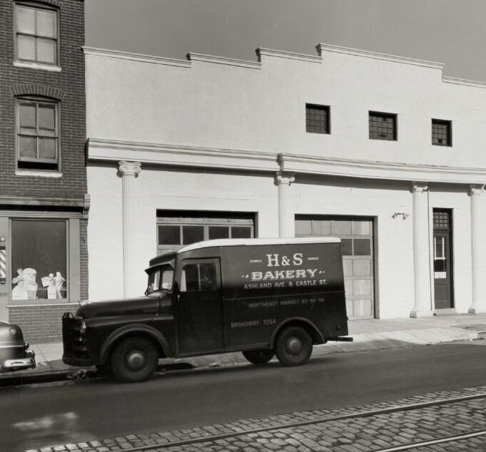 Black and white historic shot of H&S Bakery Truck in front of old building in Baltimore