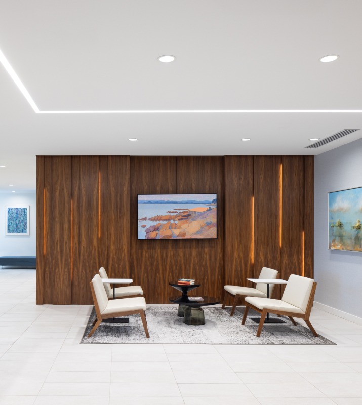 Bright, contemporary Lobby inside of 1001 Fleet Office building with dark wood walls and white flooring