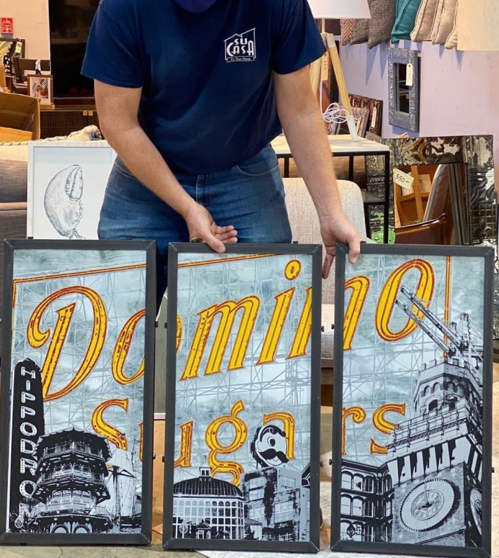 Person holding triptych framed of Domino Sugars / Baltimore-themed paintings