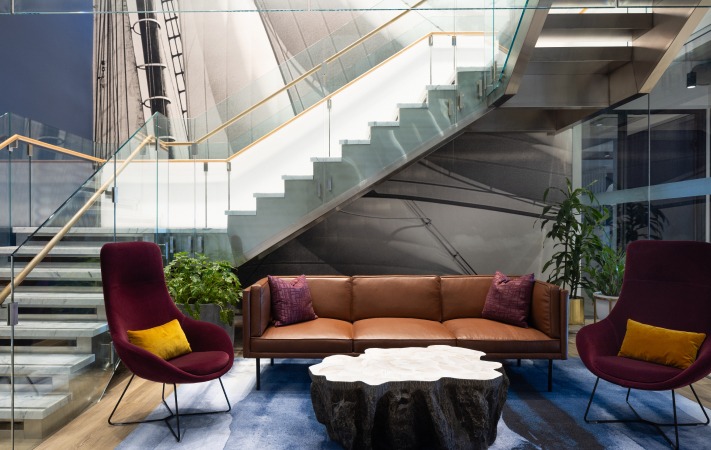 Lobby of 100 International Office Building featuring a grand glass staircase and comfortable, chic seating