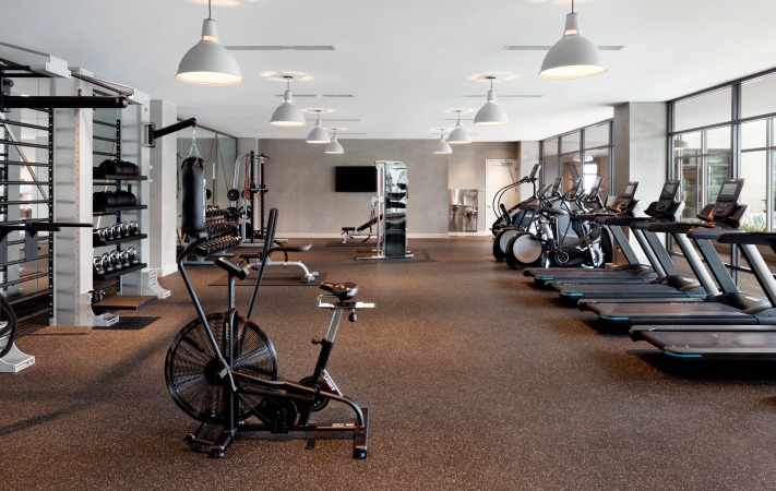 Gym with several bikes, treadmills, and free weights inside of the Liberty apartment building in Harbor East