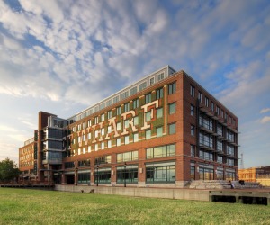 A historical brick office building, 901 S Bond St, sits at the edge of the water in Harbor East