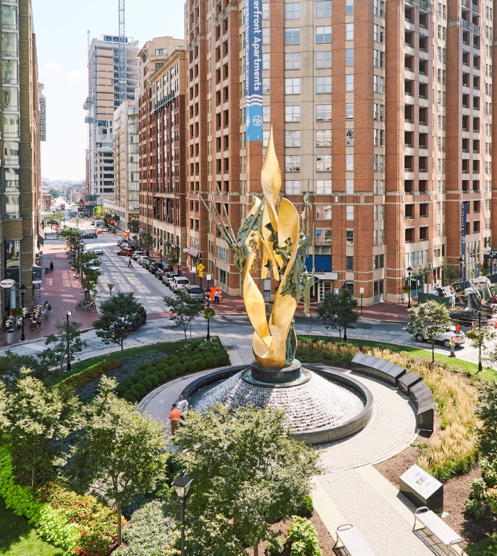 Large gold statue featuring a fountain in the center of Harbor East in Baltimore