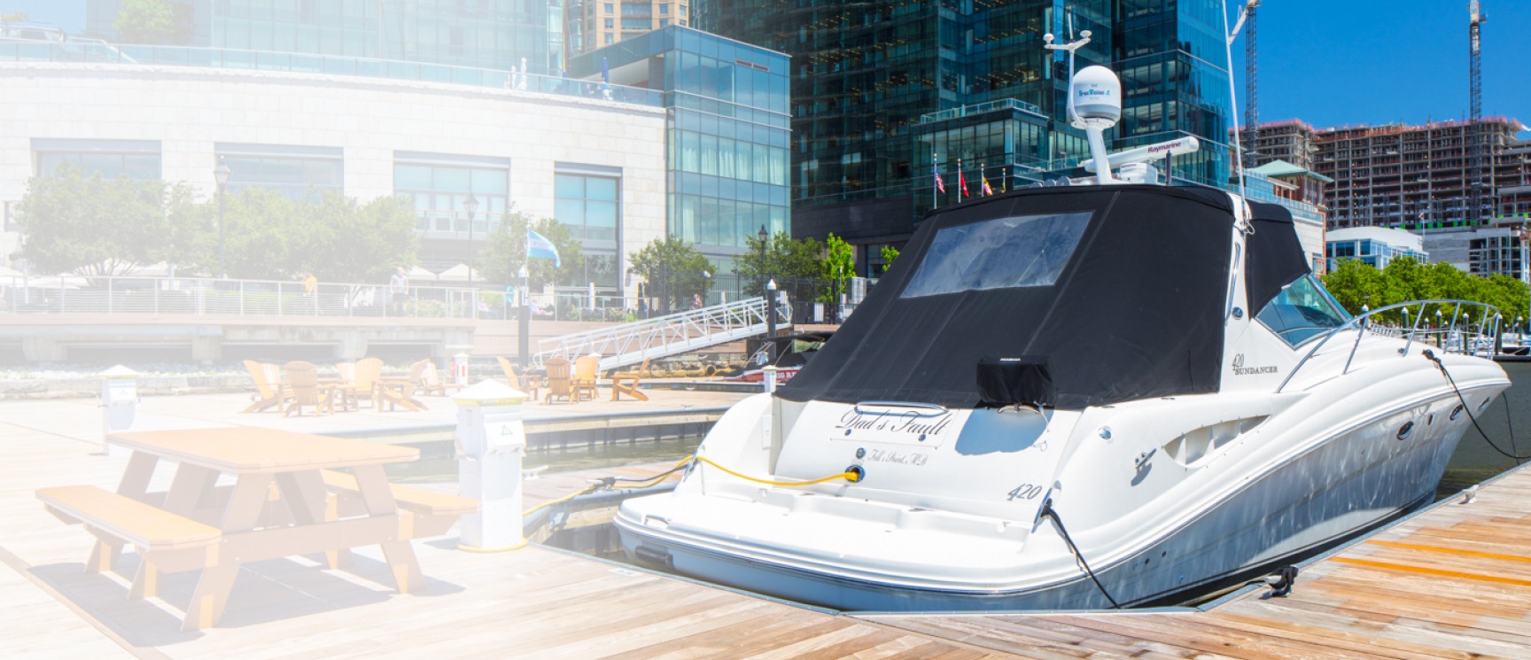 White boat docked in Harbor East Marina with picnic table and access to Harbor East
