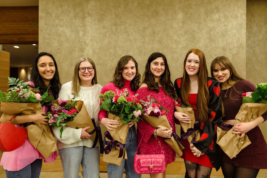 group of friends taking a photo with flower bouquets
